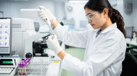 Eine medizinische Technologin für Laboratoriumsanalytik analysiert im Labor eine Blutprobe.