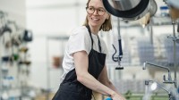 Eine Assistentin für Ernährung und Versorgung reinigt die Küche in einem Heim für Menschen mit Behinderungen.