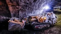 Mit dem Raupenbagger erschließen Berg- und Maschinenmänner Steinkohle in einem Bergwerk.