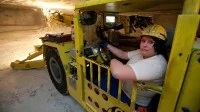 Eine Bergbautechnologin fährt im Werk Werra der K+S KALI GmbH einen Firstankerbohrwagen, der für die untertägige Gewinnung, Sicherung und Erkundung genutzt wird.