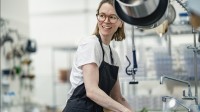 Eine Assistentin für Ernährung und Versorgung putzt die Küchenspüle in einem Heim für Menschen mit Behinderungen.