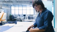 Eine bekleidungstechnische Assistentin wandelt eine Entwurfsskizze in einen Musterschnitt um.