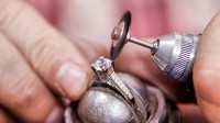 Ein Designer für angewandte Formgebung, Schmuck und Gerät repariert den Diamantring einer Kundin.