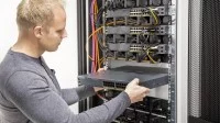 Ein Assistenten für Softwaretechnik schiebt die Hardware in den Server.