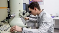 Ein physikalisch-technischer Assistent misst eine Probe am Elektronenmikroskop.