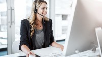 Eine kaufmännische Assistentin/ Wirtschaftsassistentin für Informationsverarbeitung führt ein Telefongespräch mit einem Kunden.