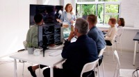 Eine kaufmännische Assistentin / Wirtschaftsassistentin für Betriebsinformatik hält für fünf Personen eine Schulung über das neue Softwareprogramm.