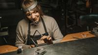 Eine Goldschmiedin arbeitet in ihrer Werkstatt an Schmuck.