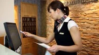 Eine Hotelfachfrau arbeitet am Empfang in einem Hotel in Essen.