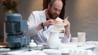 Ein Industriekeramiker arbeitet in der Besucherwerkstatt der Porzellan-Manufaktur Fürstenberg an einem Korb aus Porzellan.