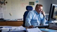 Ein Kaufmann im Eisenbahn- und Straßenverkehr bei DB Schenker organisiert den Warentransport mit Zügen.