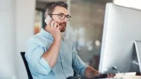 Ein Industriekaufmann telefoniert am Arbeitsplatz