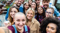 Eine Gruppe junger Erwachsener macht ein Selfie.