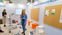 Julia Olesen steht in der Lieferkette und erklärt den Teilnehmenden des Workshops die Aufgabe.