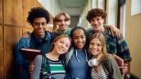 Eine Gruppe von sechs Jugendlichen in einer Schule, die in die Kamera lächeln.