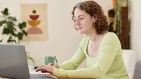 Junge Frau arbeitet am Laptop