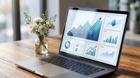 Ein Laptop auf einem Holztisch, der Bildschirm zeigt Grafiken zu Statistiken.
