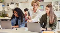 Lehrerin mit Schülerinnen im Klassenzimmer