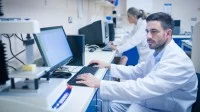 Ein Milchwirtschaftlicher Laborant untersucht mit modernster Technik ein Stück Käse.