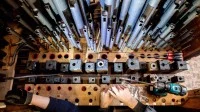 Zwei Orgelbauer bauen mehrere Orgelpfeifen der historischen Gloger-Orgel in der St. Severi-Kirche zur Restauration aus.