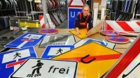 Eine Schilder- und Lichtreklameherstellerin arbeitet in den Schilderwerken Beutha an einem Auftrag für neue Verkehrsschilder.