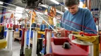 Ein Seiler spannt im Tauwerk Liros Schnüre in eine Maschine.