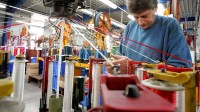 Ein Seiler spannt im Tauwerk Liros Schnüre in eine Maschine.