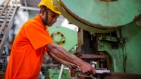 Ein Stanz- und Umformmechaniker arbeitet an der Lochstanzmaschine.