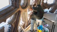 Eine Steinmetzin restauriert eine Strebe im Westturm vom Münster in Freiburg.