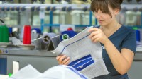 Eine Textil- und Modenäherin prüft die Qualität einer Kniebandage.
