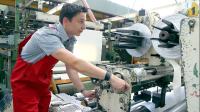Ein Kunststoff- und Kautschuktechnologe bedient eine Maschine zum Zuschneiden von Kunststofffolie.