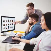 Eine Kauffrau für audiovisuelle Medien bearbeitet eine Bilddatei mit einem Grafiktablett.