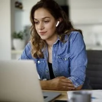 Frau sitzt vor dem Laptop.