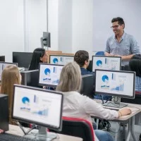 Lehrer und Auszubildende im Klassenzimmer mit PCs