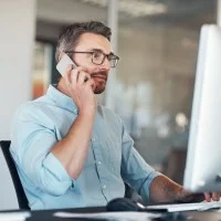 Ein Industriekaufmann telefoniert am Arbeitsplatz