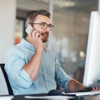 Ein Industriekaufmann telefoniert am Arbeitsplatz