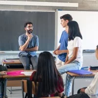 Lehrer mit Schülern im Gespräch