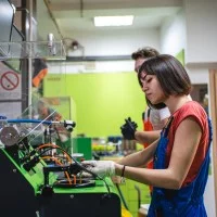 Junge Frau arbeitet an einer Maschine