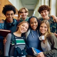 Eine Gruppe von sechs Jugendlichen in einer Schule, die in die Kamera lächeln.