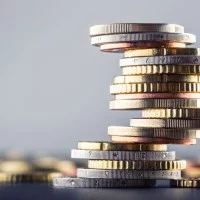 Ein Stapel von Euromünzen mit verschwommenem Hintergrund.