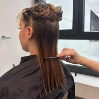 Ein Friseur-Azubi der Gewerblichen Schule Bad Mergentheim schneidet und stylt Haare. 