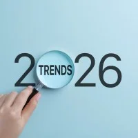 Eine Hand hält eine Lupe, die sich auf das Wort Trends innerhalb des Jahres 2026 konzentriert. 