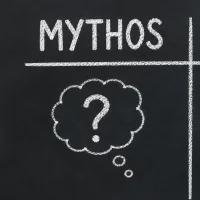 Auf einer Tafel steht Mythos und Fakt geschrieben. Vor der Tafel steht eine Lehrerin mit Kreide in der Hand.