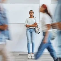 Junge Frau steht nachdenklich in einer Berufsschule