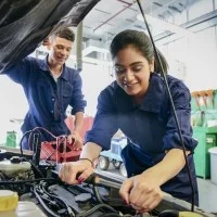 Auszubildende für Kraftfahrzeugmechatronik bei der Arbeit am Auto in der Werkstatt