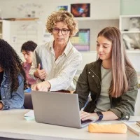 Lehrerin mit Schülerinnen im Klassenzimmer