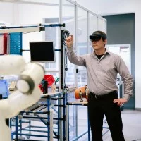 Ein Gestalter für immersive Medien erprobt eine Virtual-Reality-Simulation für einen Roboter.