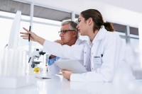 Eine medizinische Technologin für Veterinärmedizin präsentiert dem Fachtierarzt für klinische Laboratoriumsdiagnostik die Ergebnisse der Blutuntersuchung eines tierischen Patienten.