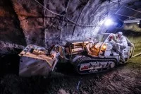 Mit dem Raupenbagger erschließen Berg- und Maschinenmänner Steinkohle in einem Bergwerk.