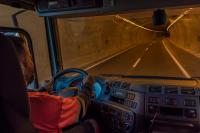 Ein Berufskraftfahrer fährt mit seinem Lastwagen durch einen Tunnel.